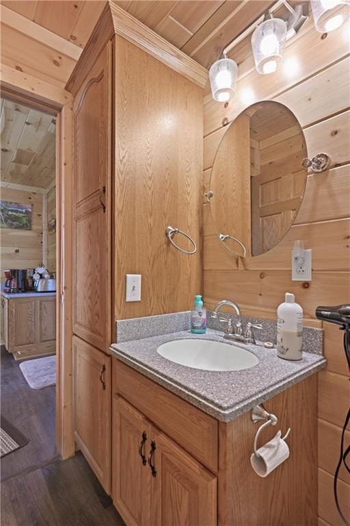 bathroom with vanity, wooden walls, wood ceiling, and hardwood / wood-style flooring