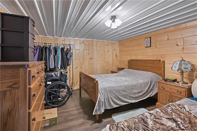 bedroom with wooden walls and dark hardwood / wood-style floors