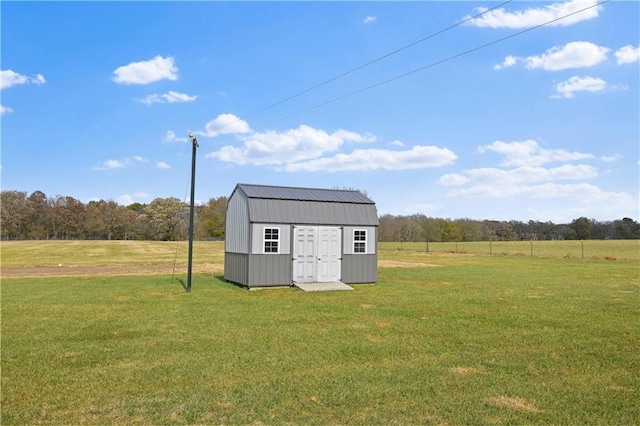 view of outbuilding featuring a rural view and a lawn