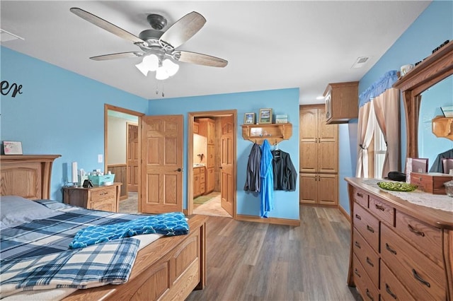 1185 Route E, Lockwood, MO 65682 - bedroom featuring connected bathroom, baseboards, visible vents, and wood finished floors