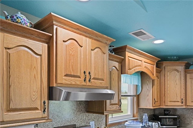 1185 Route E, Lockwood, MO 65682 - details with under cabinet range hood, visible vents, and decorative backsplash