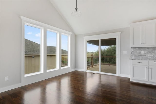 unfurnished dining area featuring dark hardwood / wood-style flooring and vaulted ceiling