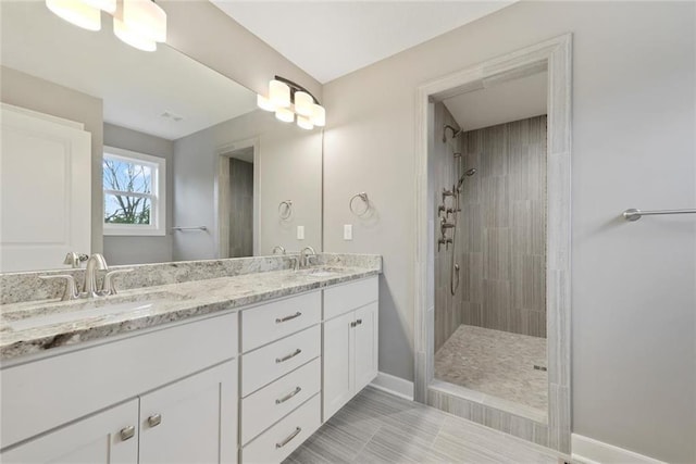 bathroom with vanity and tiled shower