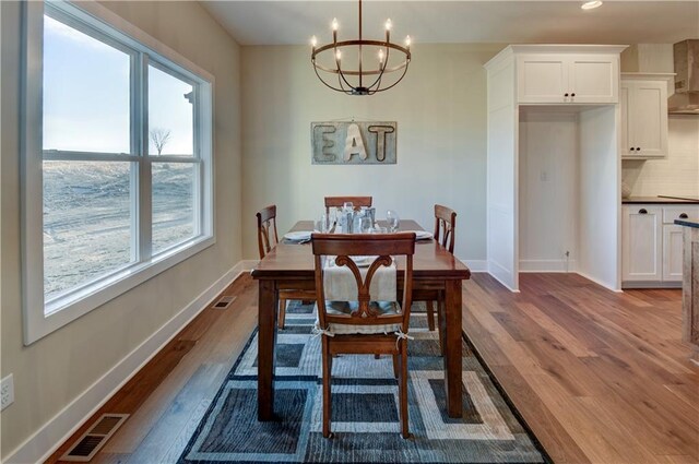 dining area featuring an inviting chandelier and hardwood / wood-style flooring