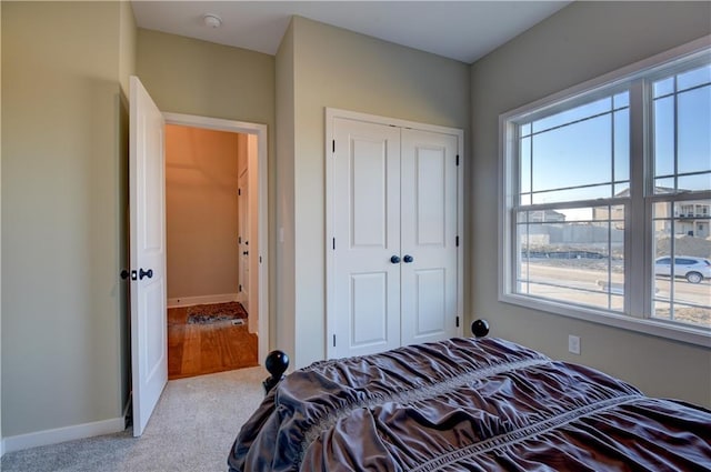 bedroom featuring light colored carpet and a closet