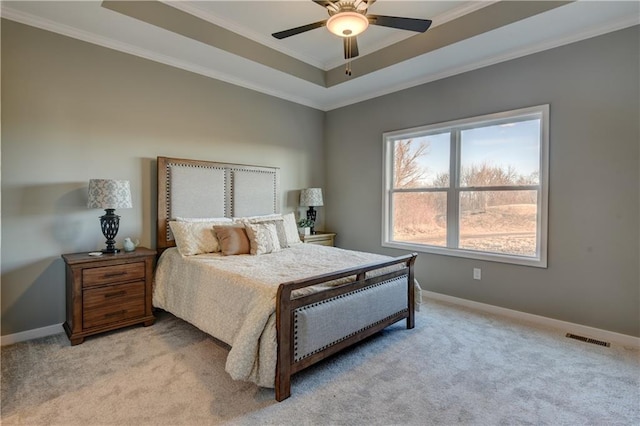 carpeted bedroom featuring ceiling fan, ornamental molding, and a raised ceiling