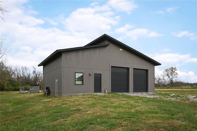 exterior space featuring a garage, an outdoor structure, and a lawn