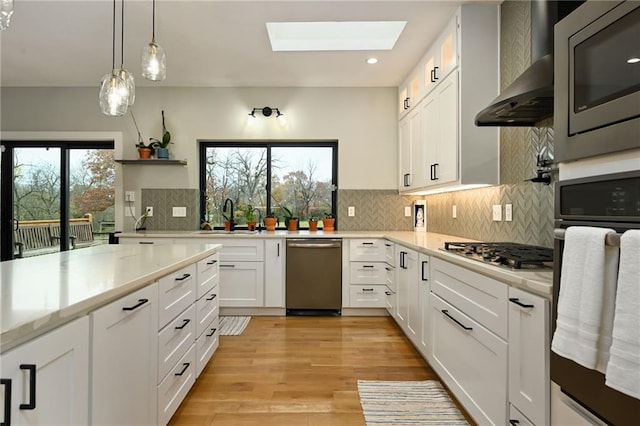 kitchen with white cabinetry, a wealth of natural light, and stainless steel appliances