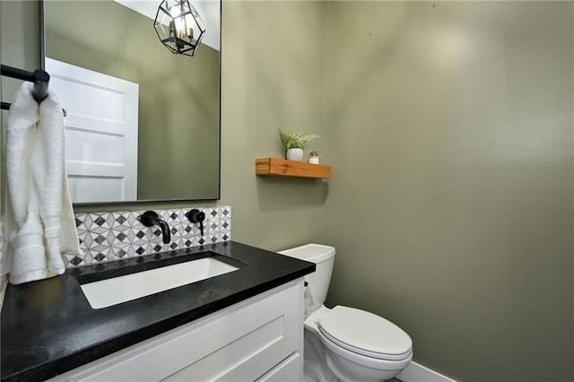 bathroom with toilet, vanity, and decorative backsplash