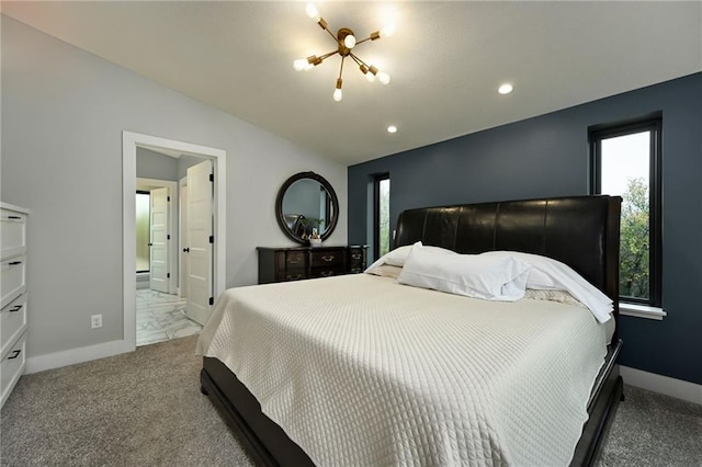 carpeted bedroom with ensuite bath and lofted ceiling