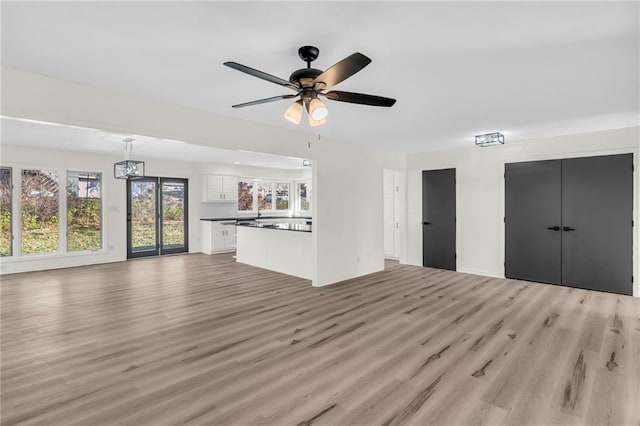 unfurnished living room featuring ceiling fan and light hardwood / wood-style flooring