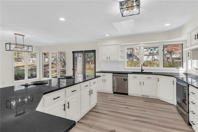 kitchen featuring sink, stainless steel appliances, light hardwood / wood-style flooring, decorative light fixtures, and white cabinets