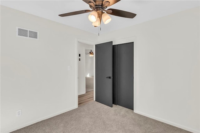 unfurnished bedroom with light carpet, a closet, and ceiling fan