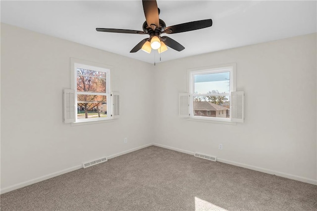 spare room with ceiling fan, carpet floors, and a wealth of natural light