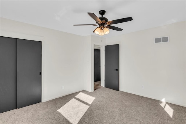 unfurnished bedroom featuring ceiling fan, a closet, and carpet floors