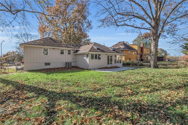 back of house with cooling unit and a yard