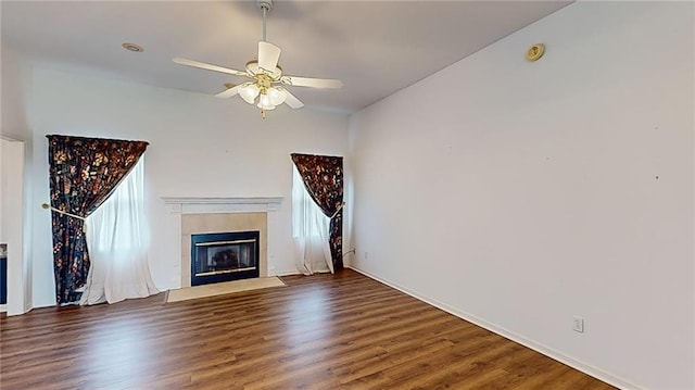 unfurnished living room featuring ceiling fan, a fireplace, and dark hardwood / wood-style floors