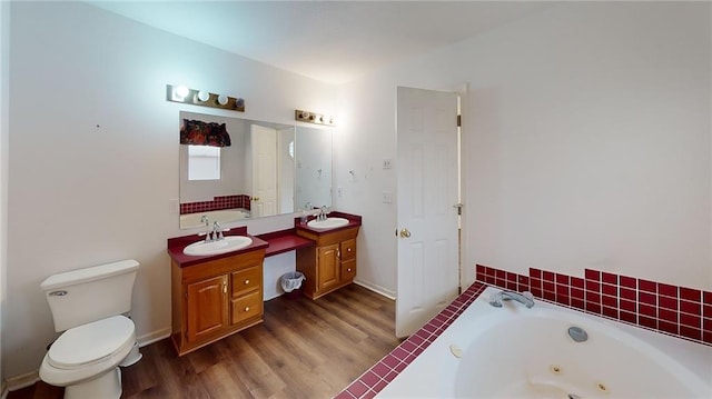 bathroom featuring hardwood / wood-style floors, vanity, toilet, and a bath