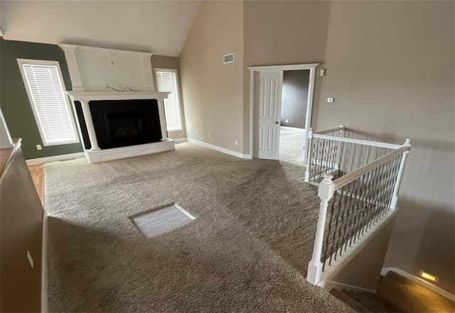 living room featuring high vaulted ceiling and carpet floors