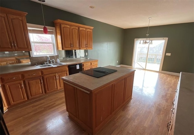 kitchen featuring black appliances, pendant lighting, sink, and a center island