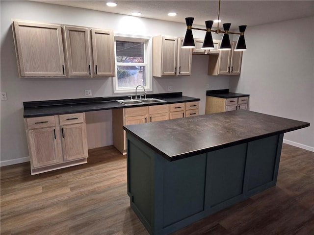 kitchen with light brown cabinetry, dark hardwood / wood-style flooring, sink, pendant lighting, and a kitchen island