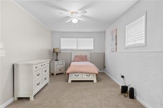 bedroom featuring ceiling fan, light carpet, and brick wall