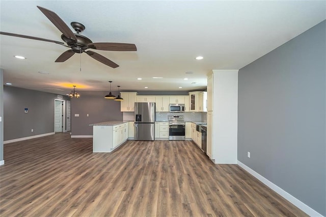 kitchen with dark hardwood / wood-style floors, decorative light fixtures, white cabinets, ceiling fan with notable chandelier, and appliances with stainless steel finishes