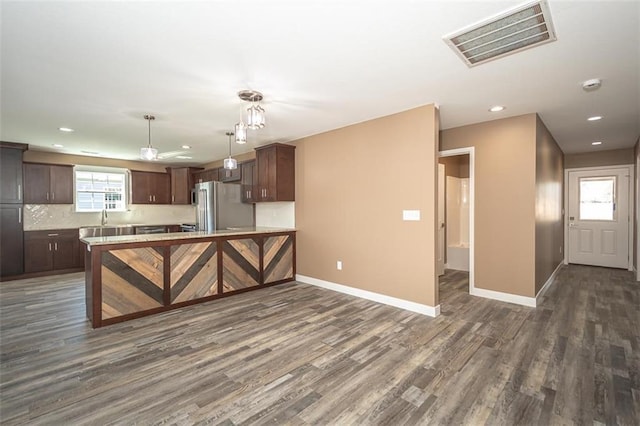 kitchen featuring freestanding refrigerator, visible vents, light countertops, baseboards, and dark wood-style floors