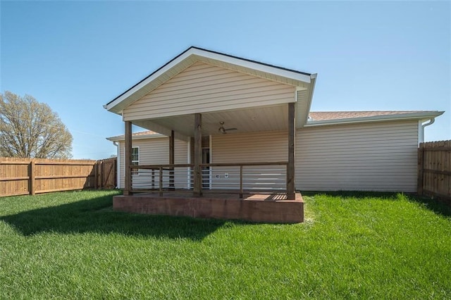 rear view of house with a yard, a fenced backyard, and a porch
