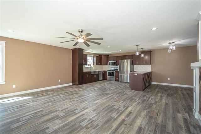 kitchen featuring open floor plan, appliances with stainless steel finishes, a sink, and light countertops