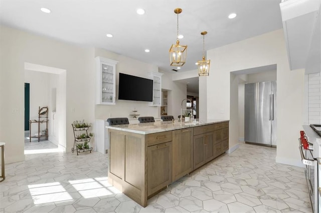 kitchen featuring appliances with stainless steel finishes, light stone counters, pendant lighting, a notable chandelier, and white cabinetry