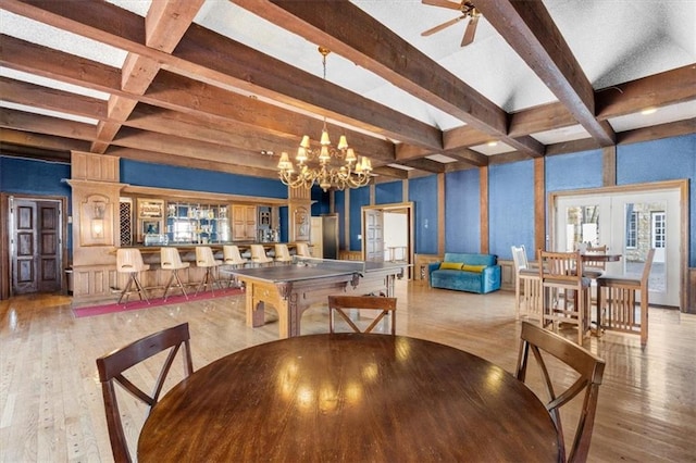 dining space with french doors, light hardwood / wood-style flooring, beamed ceiling, and ceiling fan with notable chandelier