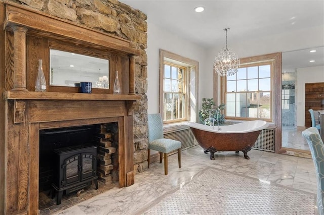 living area featuring a wood stove and a notable chandelier