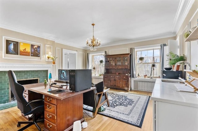 office space with ornamental molding, sink, a chandelier, and light wood-type flooring