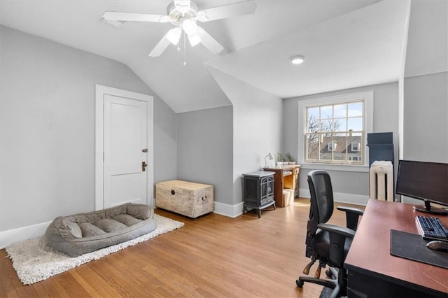 home office featuring ceiling fan, light hardwood / wood-style flooring, and vaulted ceiling