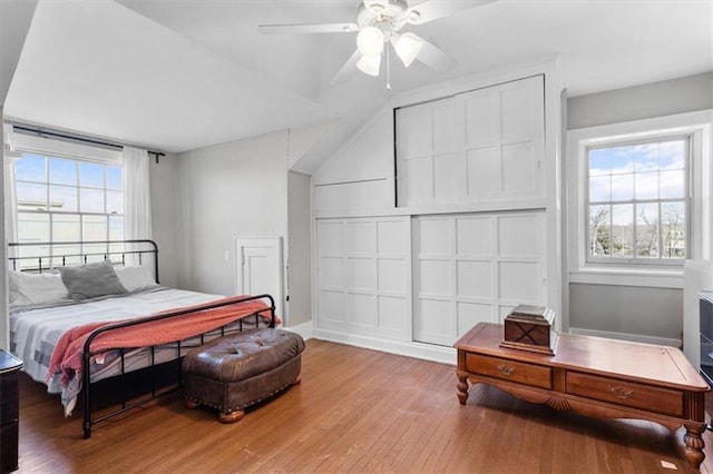 bedroom featuring ceiling fan, wood-type flooring, and vaulted ceiling