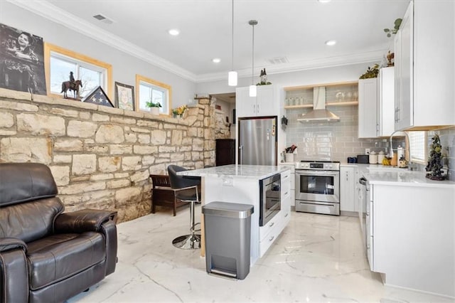 kitchen featuring white cabinetry, sink, wall chimney exhaust hood, stainless steel appliances, and a kitchen island