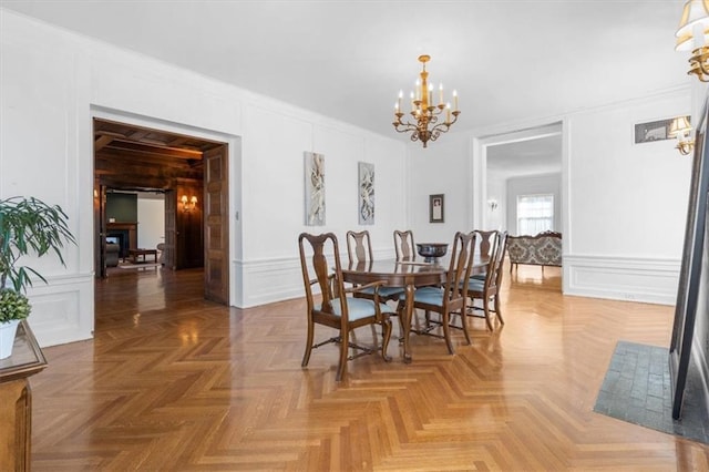 dining space with a chandelier, a decorative wall, and ornamental molding