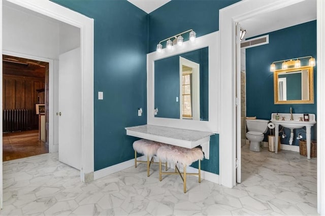 bathroom featuring toilet, marble finish floor, visible vents, and baseboards