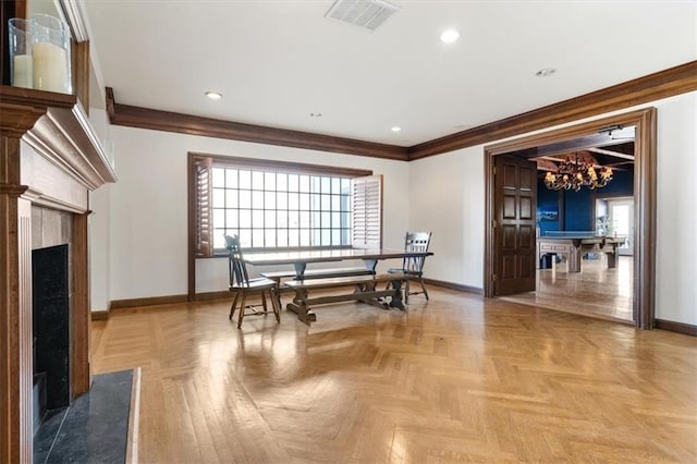 dining space with ornamental molding, visible vents, baseboards, and a premium fireplace