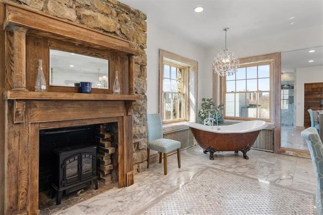 sitting room featuring a chandelier, marble finish floor, a wood stove, and recessed lighting