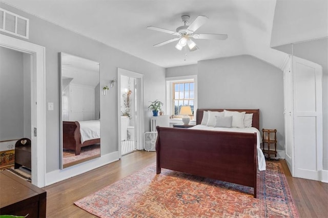 bedroom with a ceiling fan, baseboards, visible vents, and wood finished floors