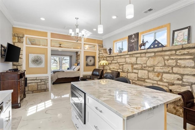 kitchen featuring white cabinets, stainless steel microwave, open floor plan, ornamental molding, and marble finish floor