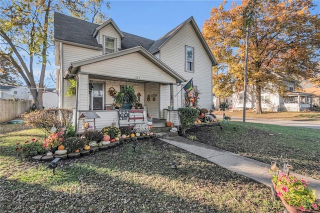 view of front of home featuring covered porch and fence