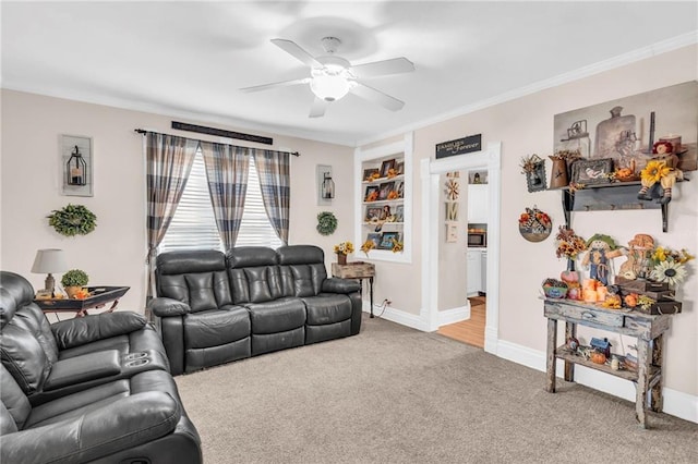 carpeted living room with built in features, ornamental molding, and ceiling fan