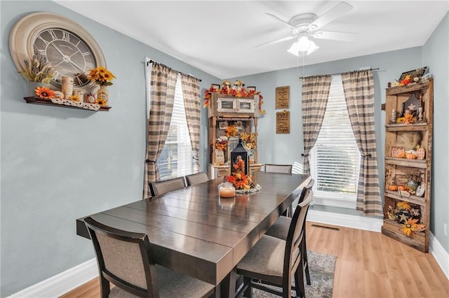 dining area with baseboards, light wood-style flooring, and ceiling fan