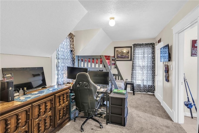 office featuring a textured ceiling, carpet floors, vaulted ceiling, and baseboards