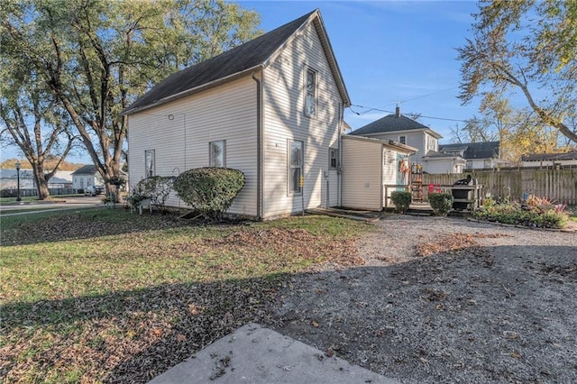 view of property exterior with a lawn and a deck