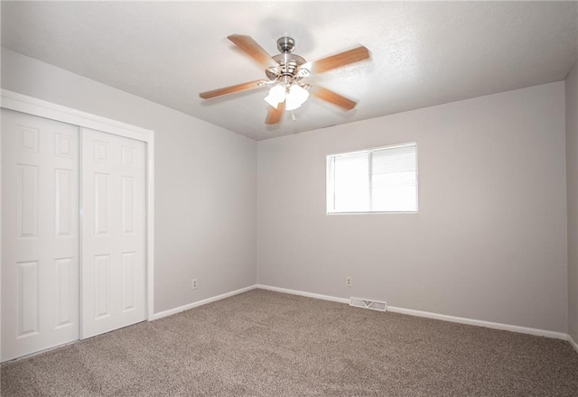 unfurnished bedroom featuring carpet floors, ceiling fan, and a closet