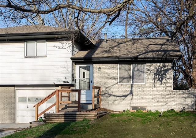 exterior space featuring a garage and a lawn